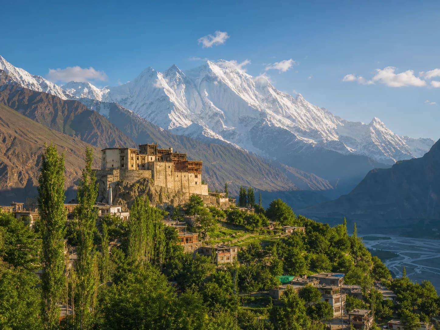 Baltit Fort above Karimabad orchards with the snow-covered Hunza mountains beyond