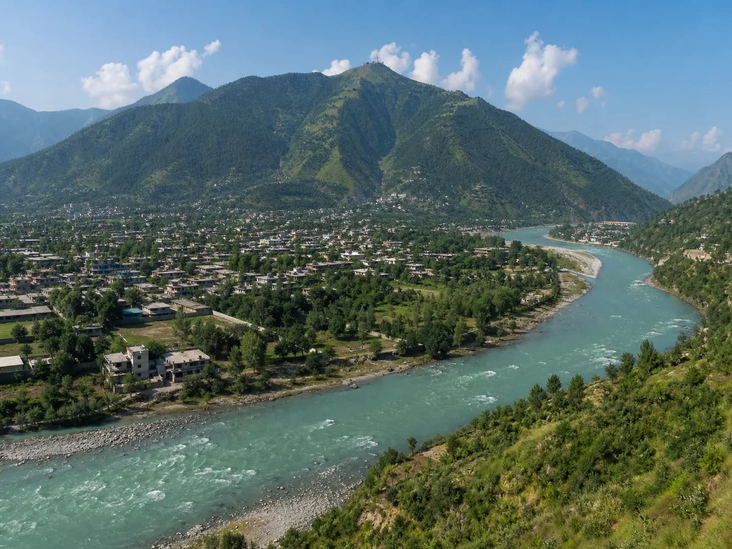 The turquoise Swat River curving past Mingora beneath the green mountains of Swat Valley